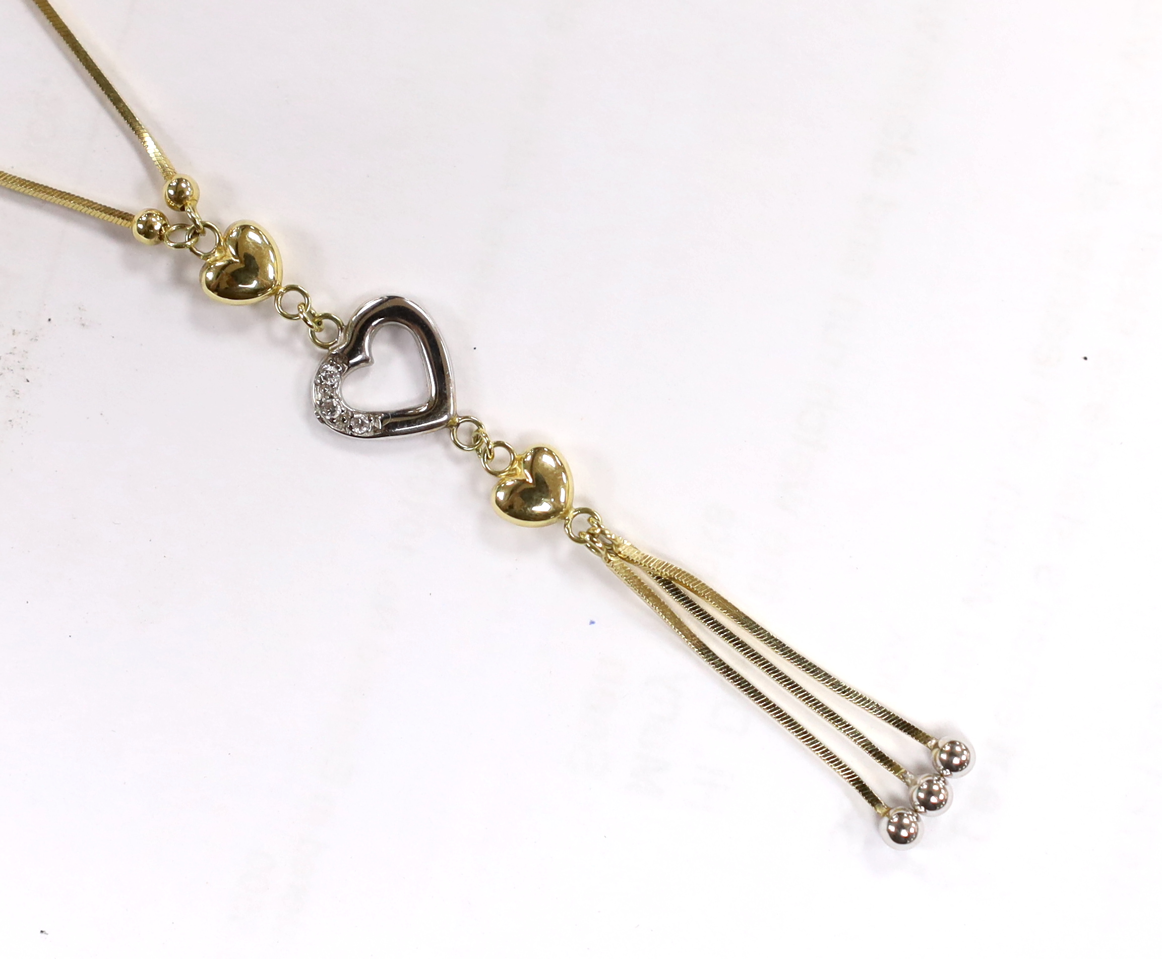 A modern two colour 14k and three white stone set heart drop tassel necklace, 56cm, gross weight, 4.7 grams.